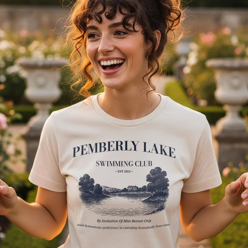 Natural t-shirt with Pemberley Lake Swimming Club design, worn outdoors in an English garden.