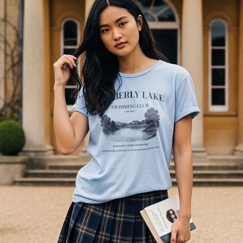 Light blue t-shirt with Pemberley Lake Swimming Club design, styled in front of a manor door.