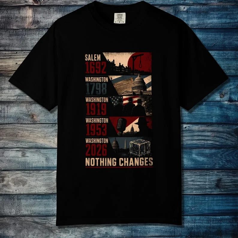 Flat Lay Blue Wood Black: Black unisex t-shirt with red and cream Constructivist timeline print, Salem to Washington 2026, on blue wood background