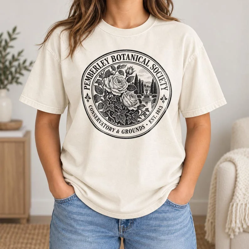 Ivory Comfort Colors Pride and Prejudice shirt with black Pemberley Botanical Society rose and estate crest.