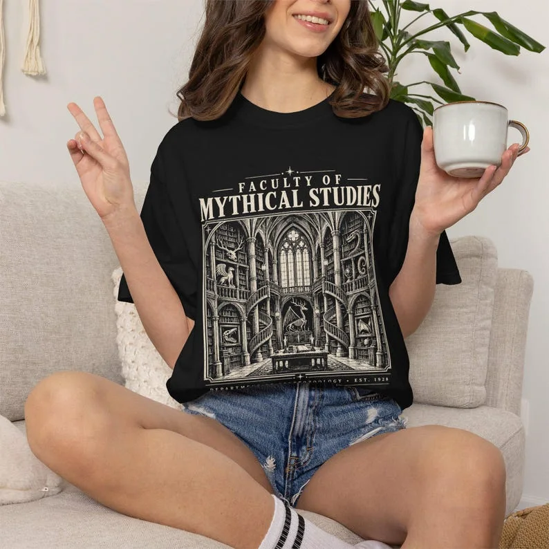 Black Comfort Colors Mythical Studies shirt featuring a Gothic library and cryptozoology academic design.